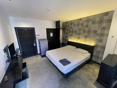 a bedroom with a bed and a black door at Cokoon Islanda Patong Hotel in Patong Beach