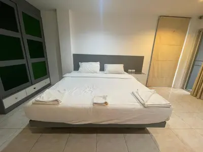 a bedroom with a large bed with white sheets at Cokoon Islanda Patong Hotel in Patong Beach