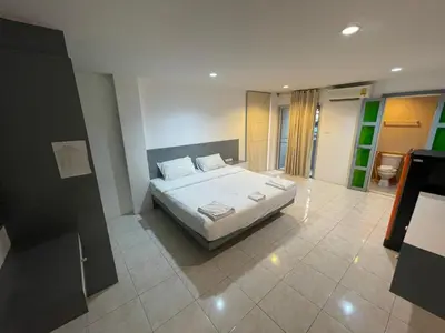a bedroom with a white bed in a room at Cokoon Islanda Patong Hotel in Patong Beach