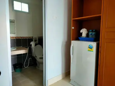 a small bathroom with a refrigerator and a toilet at Pailin Hill Hotel Patong in Patong Beach
