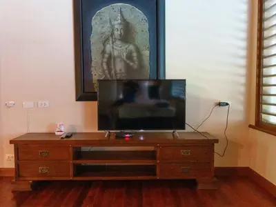 a tv sitting on top of a wooden dresser at Patong 4BD sea view BOOM party&cozy pool villa in Ban Nakhale