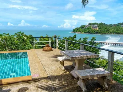 a balcony with a picnic table and a view of the ocean at Patong 4BD sea view BOOM party&cozy pool villa in Ban Nakhale
