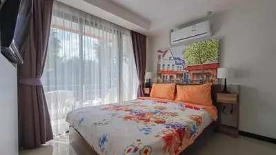 a bedroom with a bed and a large window at Квартира in Mai Khao Beach