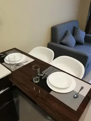 a table with two white plates on it with a couch at Квартира in Mai Khao Beach