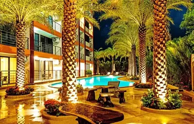 a hotel lobby with palm trees and a swimming pool at Квартира in Mai Khao Beach