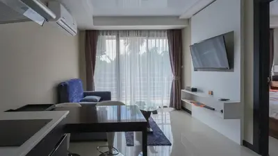 a small living room with a table and a television at Квартира in Mai Khao Beach