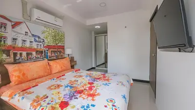 a bedroom with a bed and a flat screen tv at Квартира in Mai Khao Beach