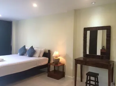 a bedroom with a bed and a mirror and a stool at Glitter House in Phuket Town