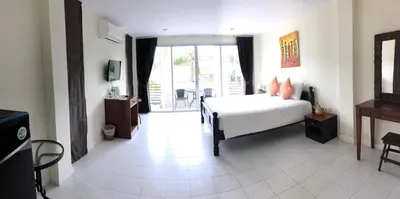 a bedroom with a white bed and a large window at Glitter House in Phuket Town