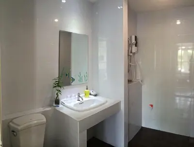 a bathroom with a sink and a toilet and a mirror at Glitter House in Phuket Town