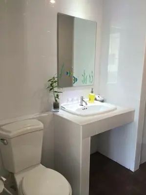 a bathroom with a sink and a toilet and a mirror at Glitter House in Phuket Town