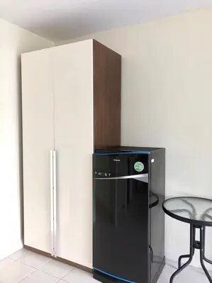 a black refrigerator in a room with a table at Glitter House in Phuket Town