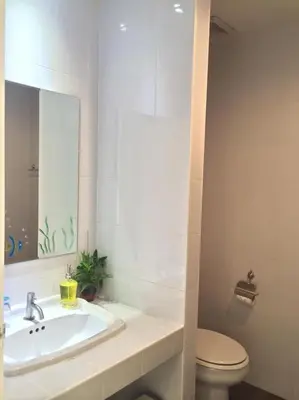 a bathroom with a sink and a toilet and a mirror at Glitter House in Phuket Town