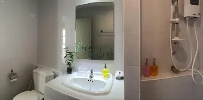 a bathroom with a sink and a toilet and a mirror at Glitter House in Phuket Town