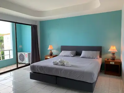 a bedroom with a bed with a blue wall at Kamalaburi Guesthouse in Kamala Beach