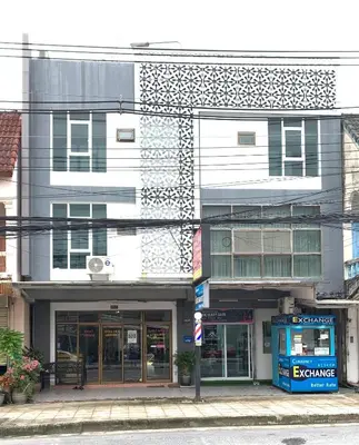 a building on a street with a phone booth in front at Kamalaburi Guesthouse in Kamala Beach