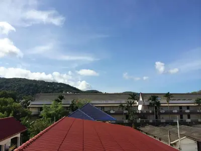 a building with a red roof with a blue solar panel at Glitter House Phuket in Kata Beach