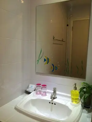 a bathroom with a sink and a mirror at Glitter House Phuket in Kata Beach