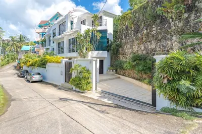 a white house on the side of a street at White Villa Patong in Patong Beach