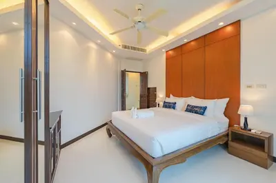a bedroom with a bed and a ceiling fan at White Villa Patong in Patong Beach