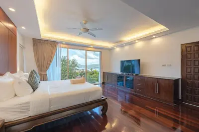 a bedroom with a bed and a ceiling fan at White Villa Patong in Patong Beach