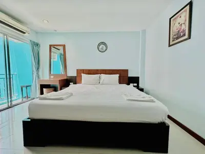 a bedroom with a large bed with white sheets at Cokoon Deva Patong Hotel in Patong Beach