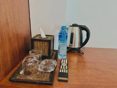 a tray with a bottle of water and glasses on a table at Cokoon Deva Patong Hotel in Patong Beach