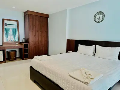 a bedroom with a large bed with a towel on it at Cokoon Deva Patong Hotel in Patong Beach