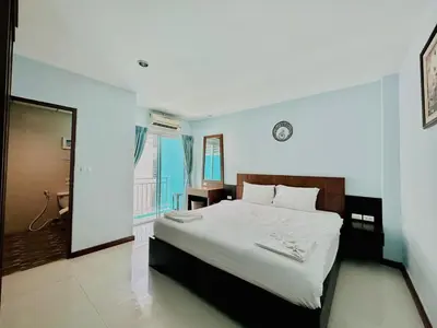 a bedroom with a large white bed with a window at Cokoon Deva Patong Hotel in Patong Beach