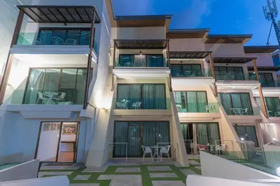 an external view of a building with tables and chairs at Destination Patong in Patong Beach