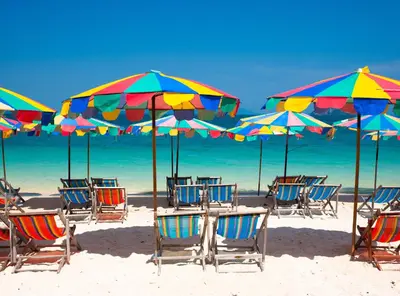 a group of chairs and umbrellas on a beach at La Vista Patong Hotel in Patong Beach