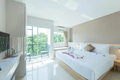 a white bedroom with a large bed and a window at La Vista Patong Hotel in Patong Beach