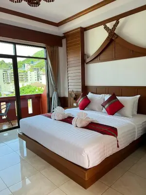 a bedroom with a large bed with red and white pillows at Vice City guest house in Patong Beach