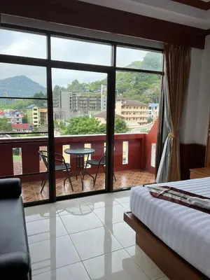 a bedroom with a view of a balcony with a table at Vice City guest house in Patong Beach