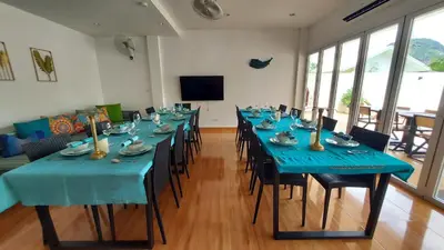 a room with a long table with blue tables and chairs at 8 Palm Villa - Large Private Pool Villas in Aonang in Ao Nang Beach