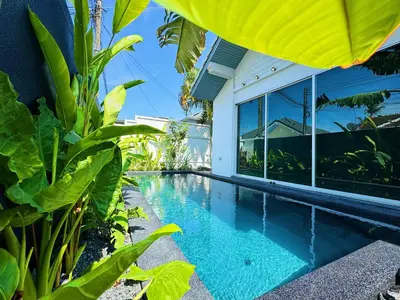 a swimming pool in front of a house at Contemporary 3bd Safari Pool Villa Near Nai Yang Beach in Ban Bo Han