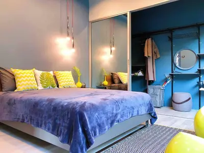 a bedroom with a bed with blue walls and yellow pillows at Contemporary 3bd Safari Pool Villa Near Nai Yang Beach in Ban Bo Han