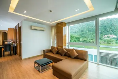 a living room with a couch and a large window at Sea view apartment at The Privilege by Lofty in Patong Beach