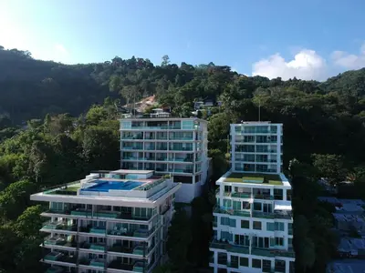 two tall buildings in front of a mountain at Sea view apartment at The Privilege by Lofty in Patong Beach