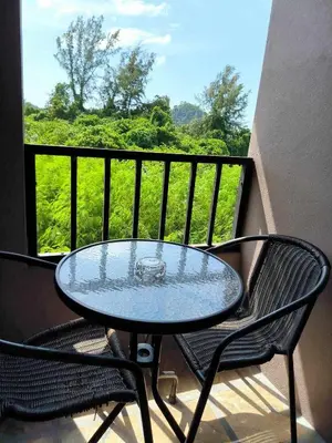 a glass table and two chairs on a balcony at The Morning mini house aonang - 15-45 years old only in Ao Nang Beach