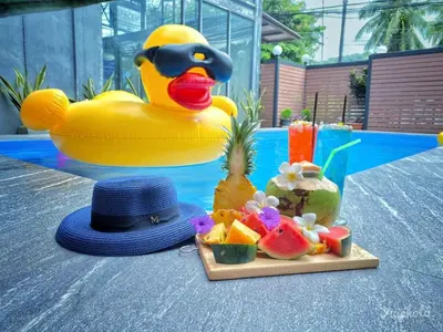 a plastic rubber duck with a hat and a tray of fruit at The Morning mini house aonang - 15-45 years old only in Ao Nang Beach