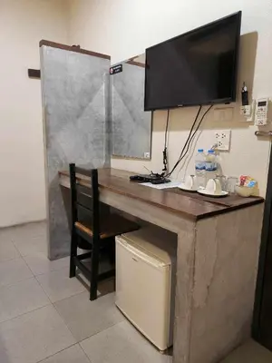 a desk with a television on a wall with a chair at The Morning mini house aonang - 15-45 years old only in Ao Nang Beach