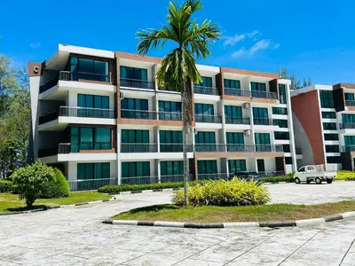 a palm tree in front of a large building at Brand Naithon CondoC404 in Nai Thon Beach