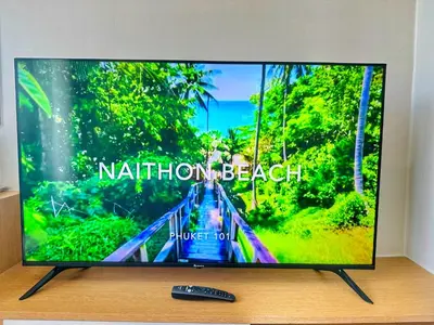 a flat screen tv sitting on a table with a remote control at Brand Naithon CondoC404 in Nai Thon Beach