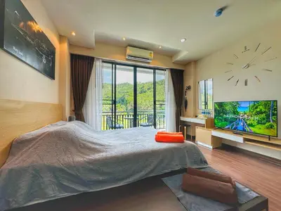 a bedroom with a large bed and a large tv at Brand Naithon CondoC404 in Nai Thon Beach