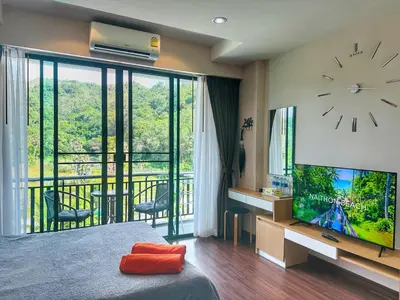 a bedroom with a large clock and a tv at Brand Naithon CondoC404 in Nai Thon Beach