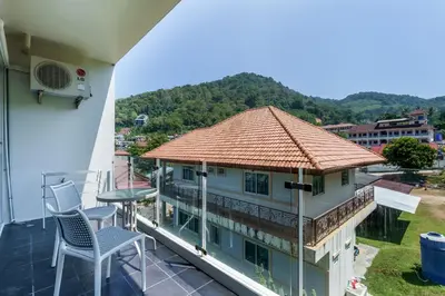 a balcony with a table and chairs on a building at Chic Condominium by Redfox Hospitality in Karon Beach