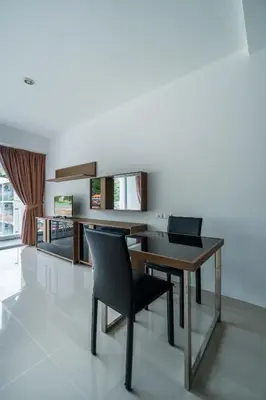 a dining room with a wooden table and chairs at Chic Condominium by Redfox Hospitality in Karon Beach
