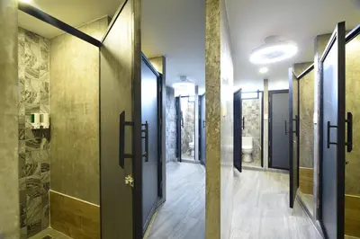a corridor of a bathroom with glass doors at KOKO Party Hostel 18-40 in Ao Nang Beach