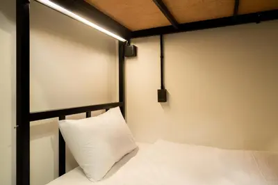 a bed with a white pillow in a room at KOKO Party Hostel 18-40 in Ao Nang Beach